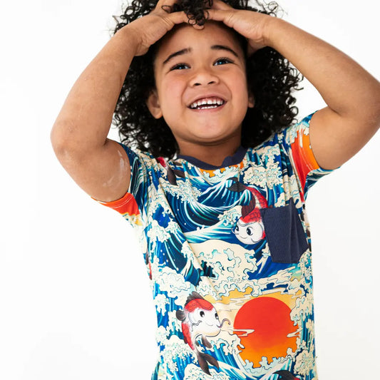 Child wearing a colorful shirt with a fish design on a white background