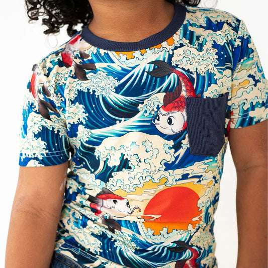 Child wearing a colorful t-shirt with cartoon character and wave design
