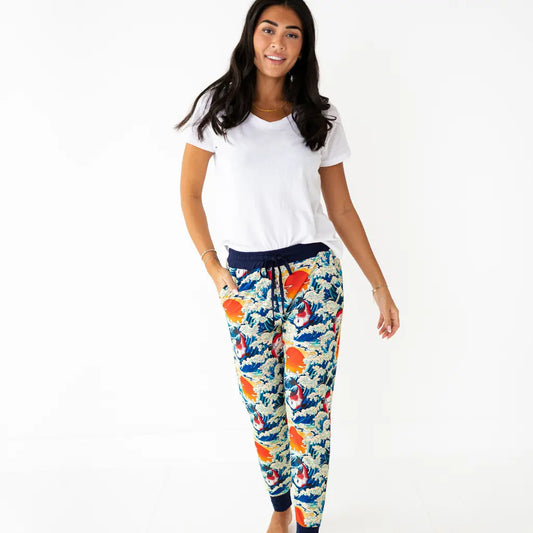 Woman wearing a white t-shirt and colorful floral pants on a white background