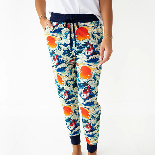 Colorful floral-patterned jogger pants worn by a person on a white background
