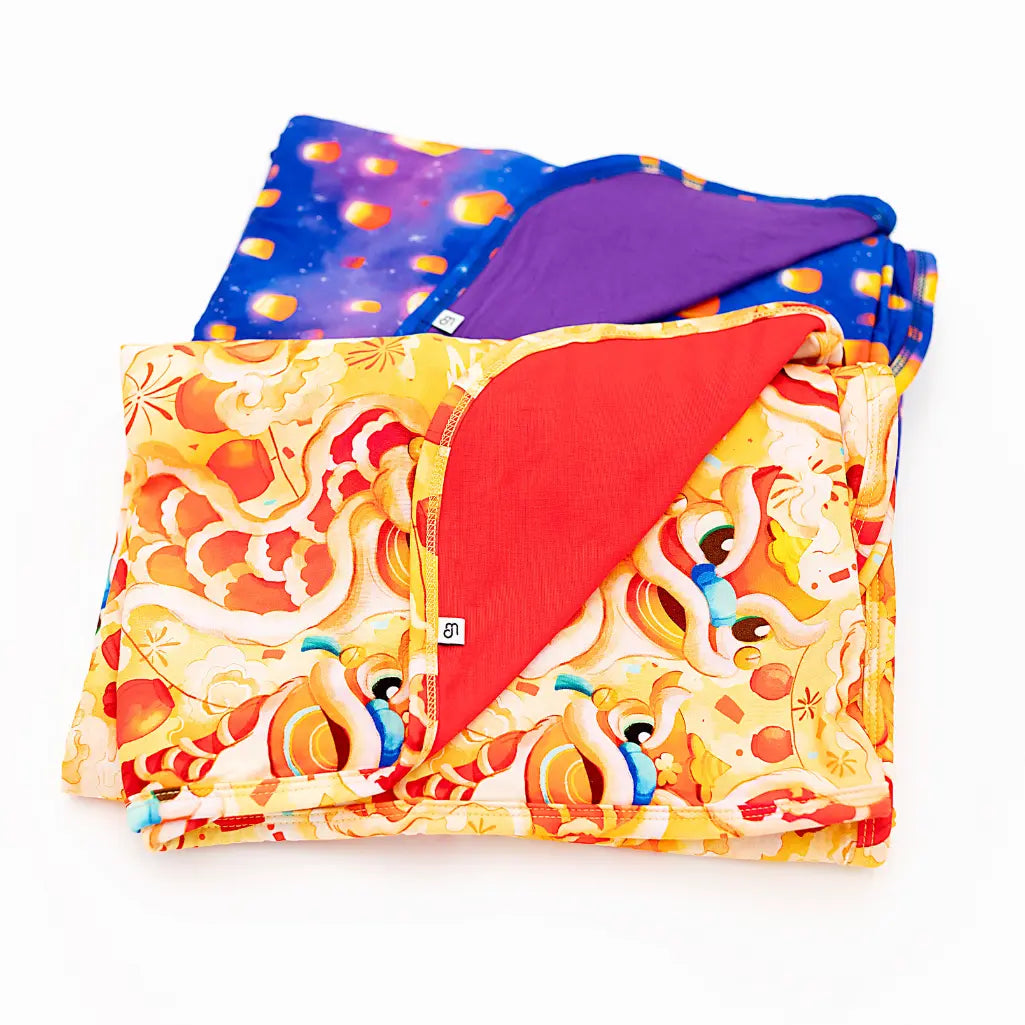 Colorful quilt with red corner and patterned design on a white background