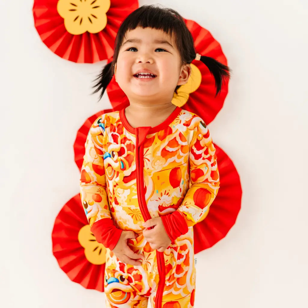 Child wearing a colorful outfit with red and yellow decorations on a white background