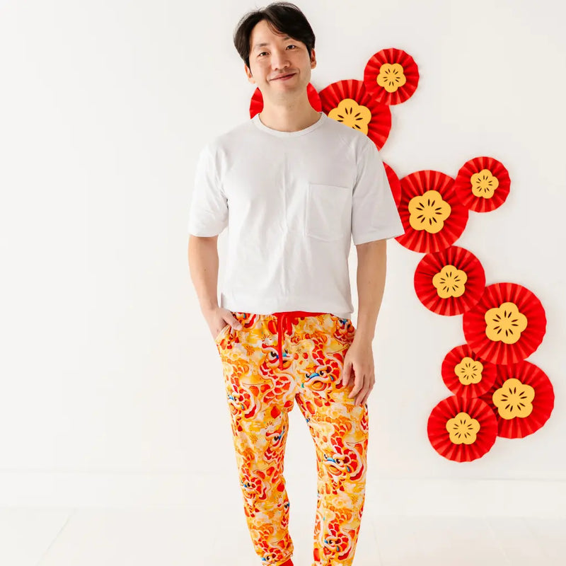 Person wearing a white shirt and colorful pants with decorative elements on a white background