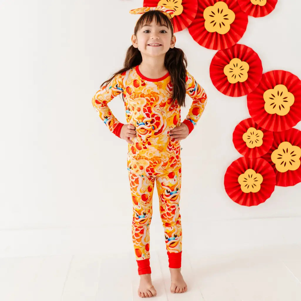 Child wearing a colorful pajama set with floral patterns against a white background