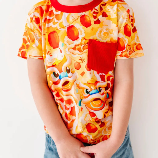 Person wearing a colorful t-shirt with cartoon character design on a plain background