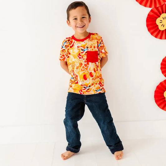 Child wearing a colorful shirt with cartoon characters on a white background