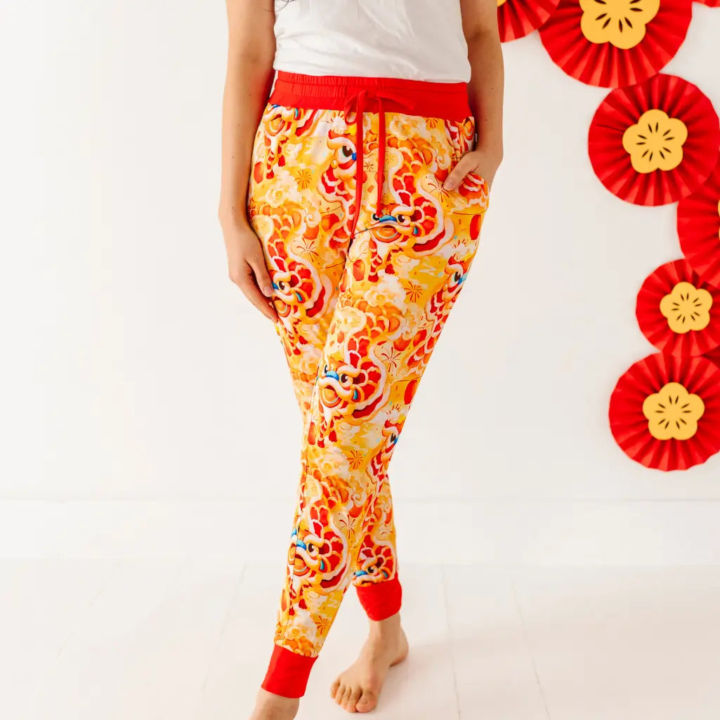 Person wearing colorful pajama pants with a red waistband on a white background