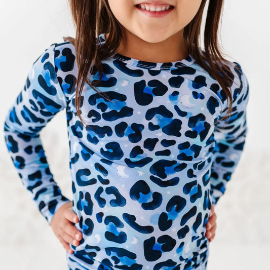 Child wearing a blue and black leopard print long-sleeve shirt on a white background