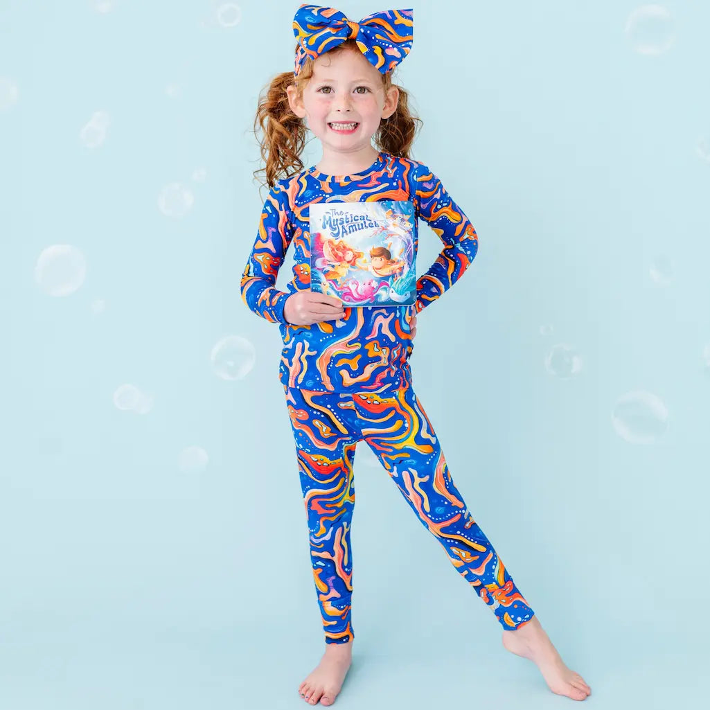 Child wearing a colorful animal print outfit with a blue background.