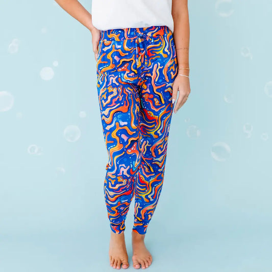 Colorful abstract-patterned leggings worn by a person on a blue background.