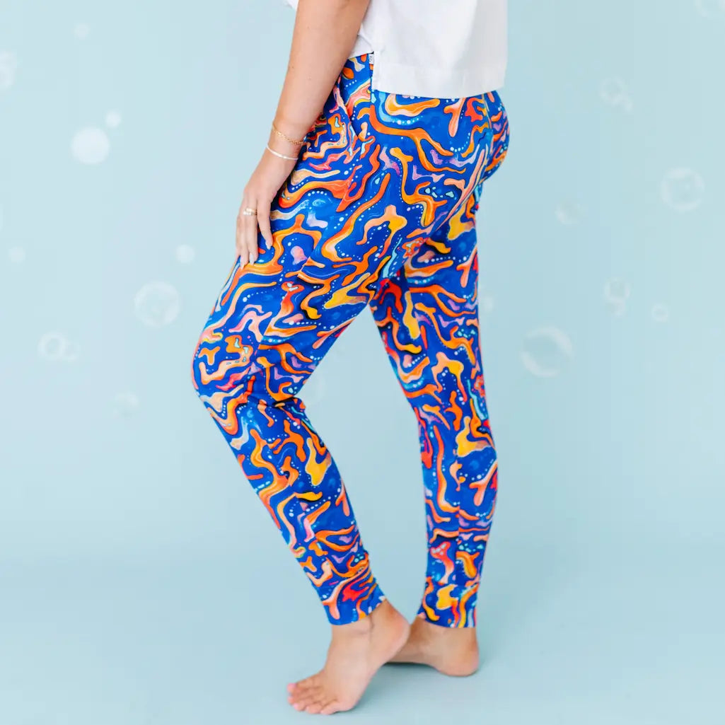 Colorful abstract-patterned leggings worn by a person on a light blue background.