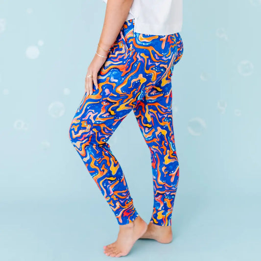 Colorful abstract-patterned leggings worn by a person on a light blue background.