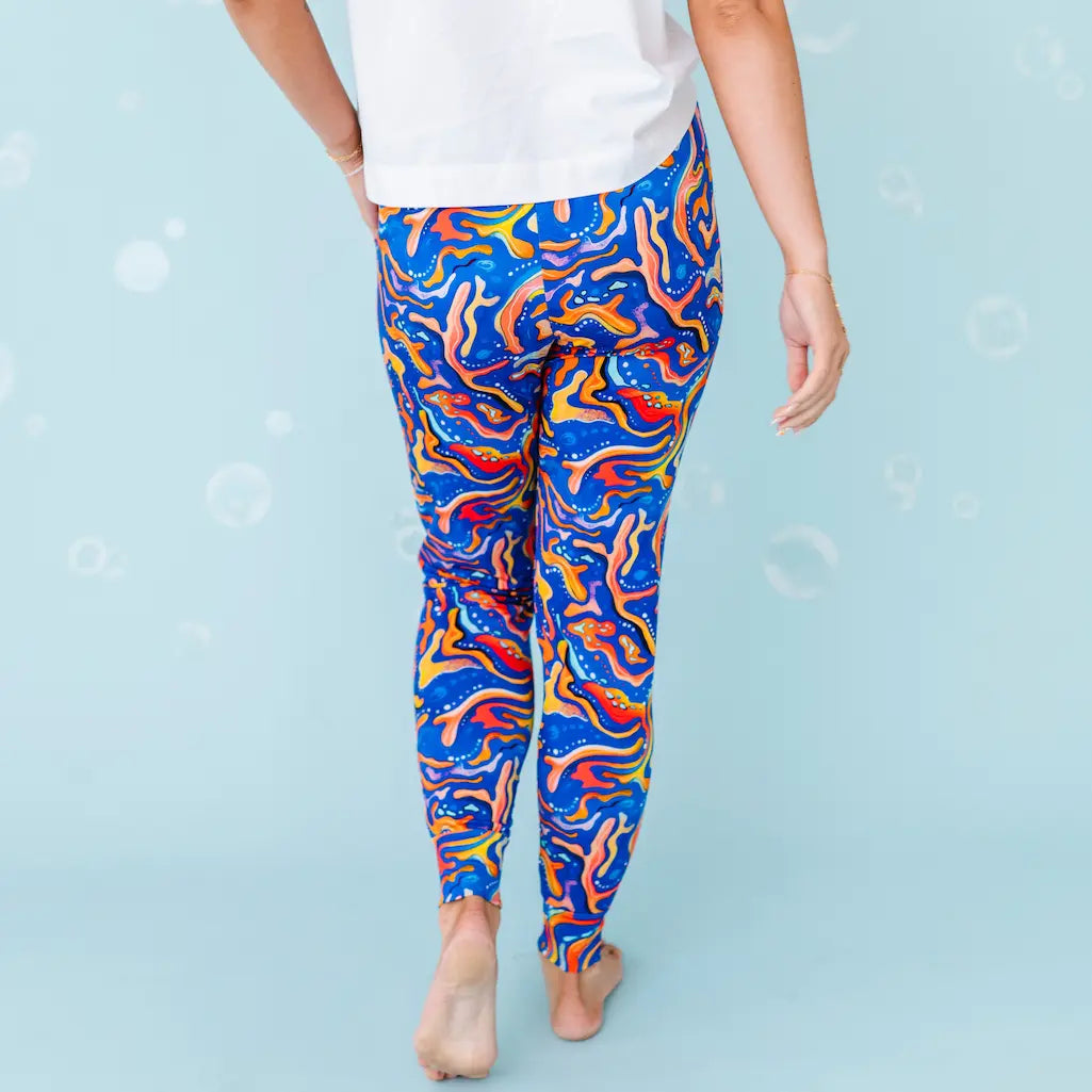 Person wearing colorful abstract-patterned leggings on a light blue background