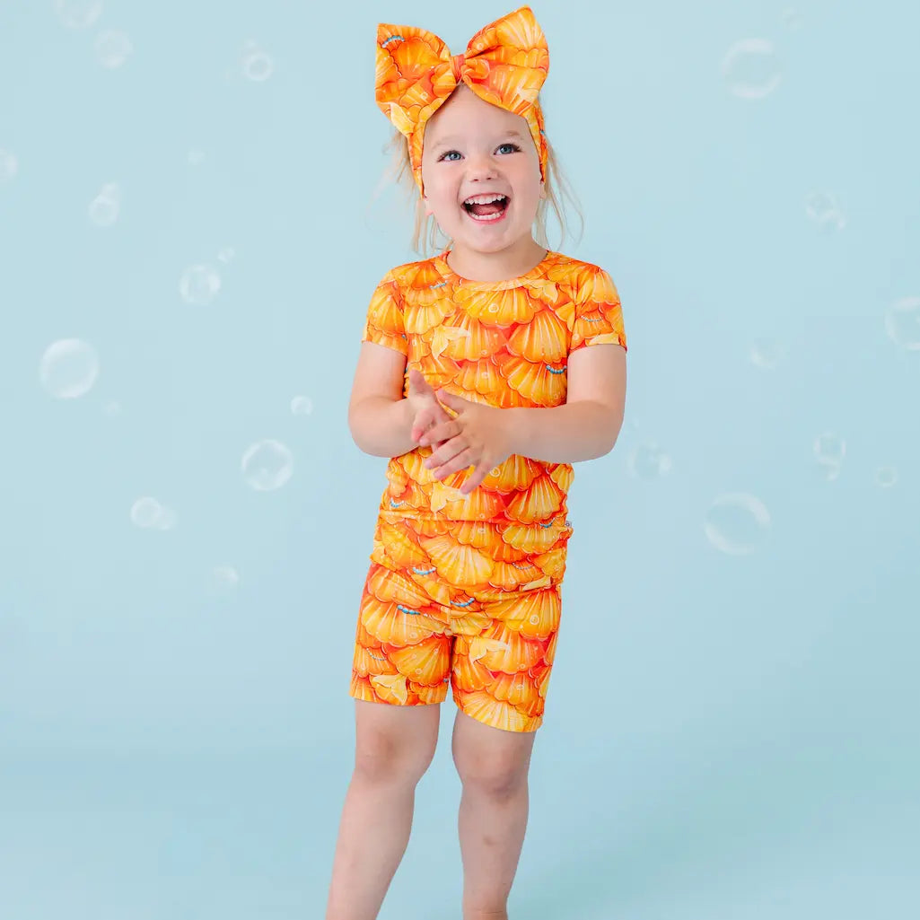 Child in orange swimsuit with pumpkins on a blue background