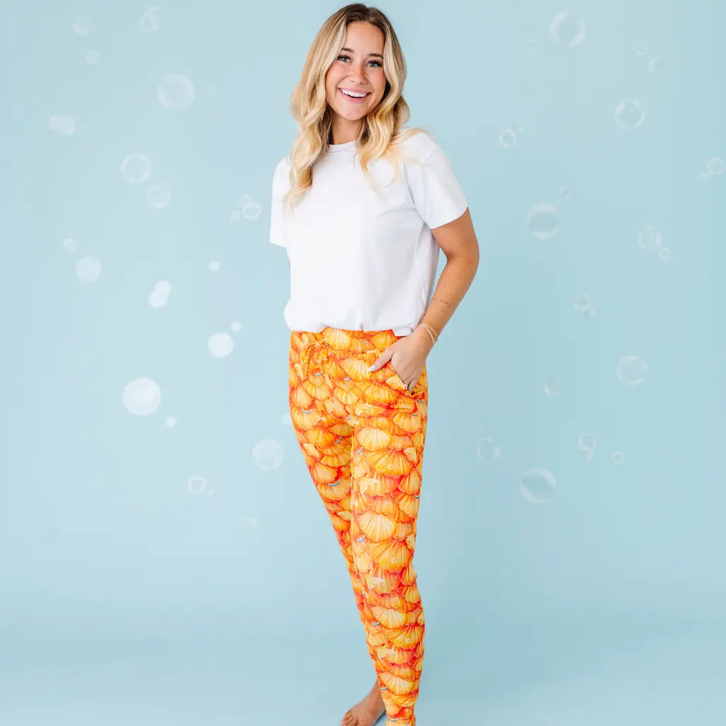 Woman wearing orange patterned leggings on a light blue background