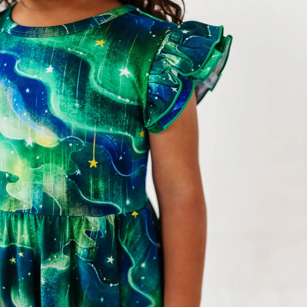 Child wearing a dress with a starry night design on a plain background