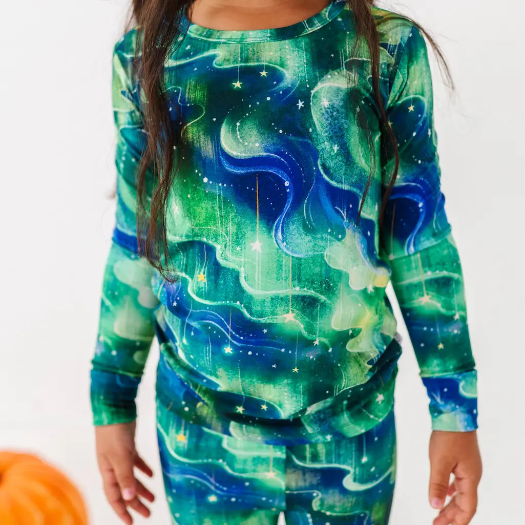 Person wearing a green and blue galaxy-themed outfit on a white background