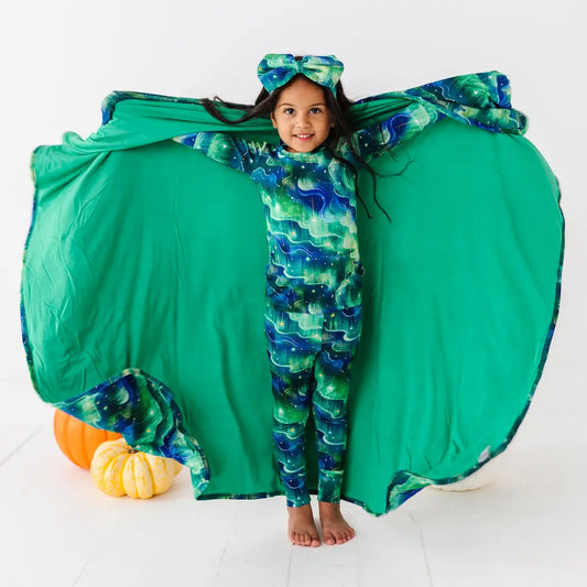 Child wearing a green butterfly costume with wings open on a white background
