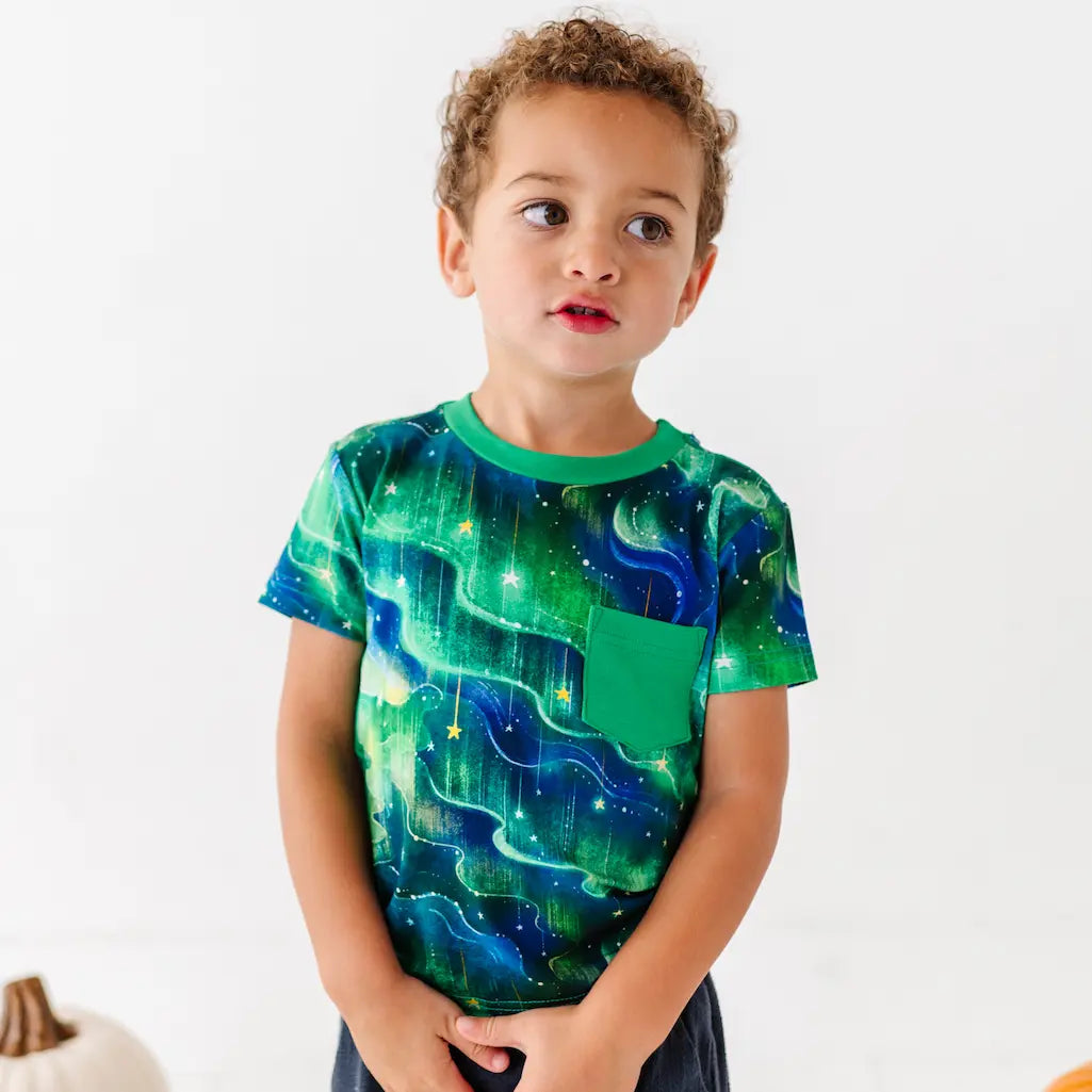 Child wearing a green and blue patterned shirt on a white background
