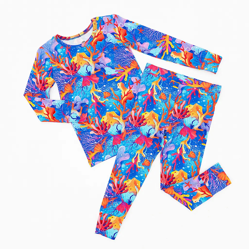 A colorful pajama set with a pattern of vibrant corals, starfish, and sea plants in brilliant blues, oranges, and purples.