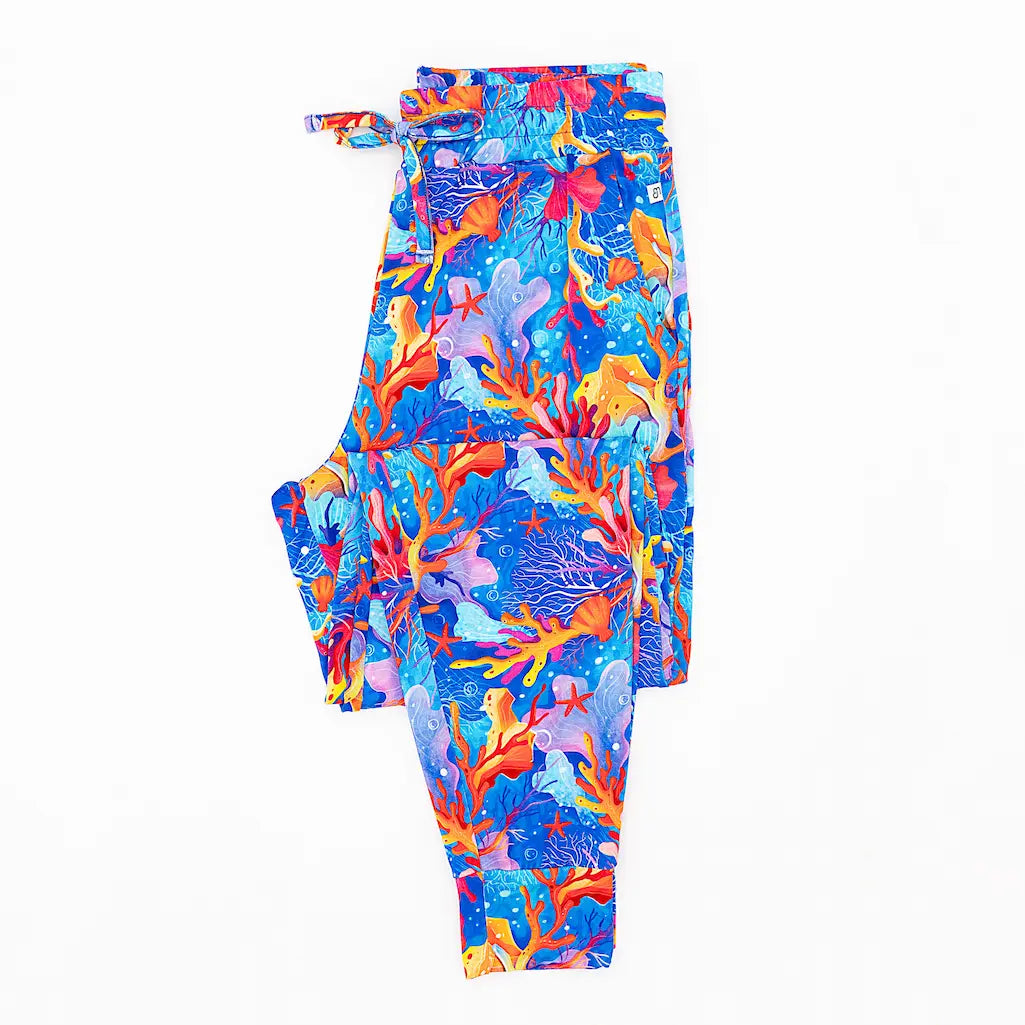 A pair of men's pajama pants with a vibrant coral reef pattern.