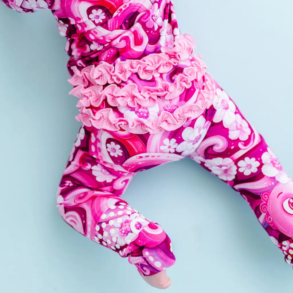 Pink and white patterned leggings on a person against a light blue background