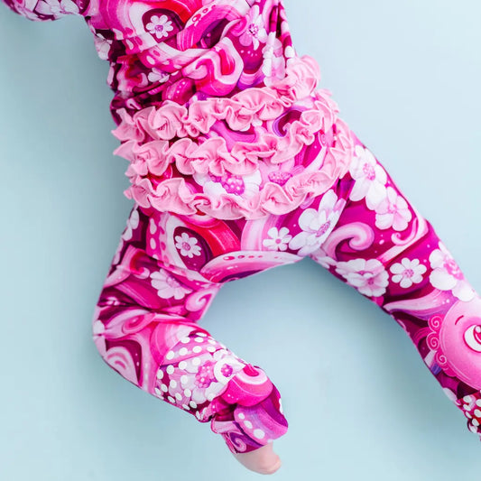 Pink and white patterned leggings on a person against a light blue background