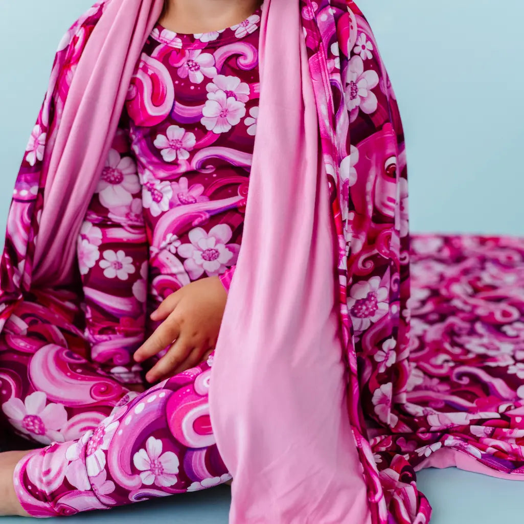 Person wearing a pink and purple floral dress on a blue background