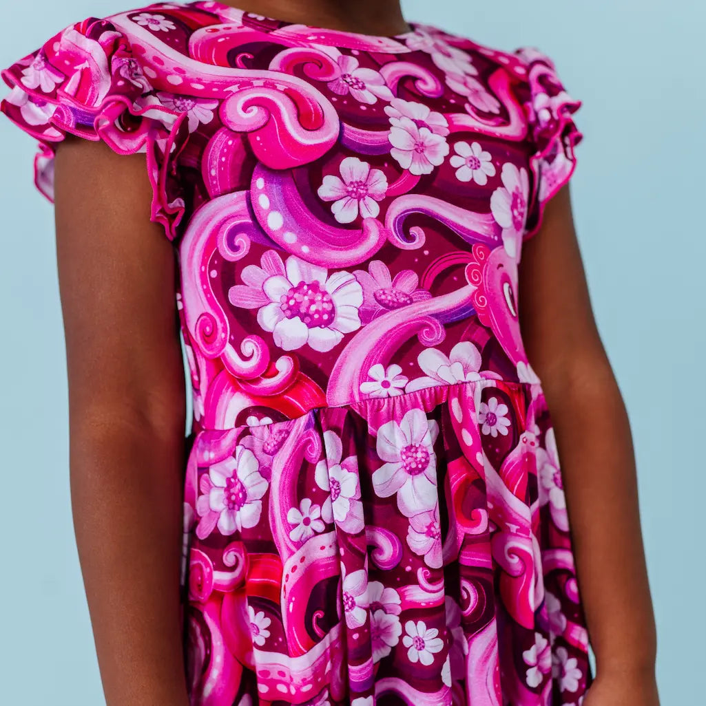 Pink and white floral dress with ruffled sleeves on a light blue background