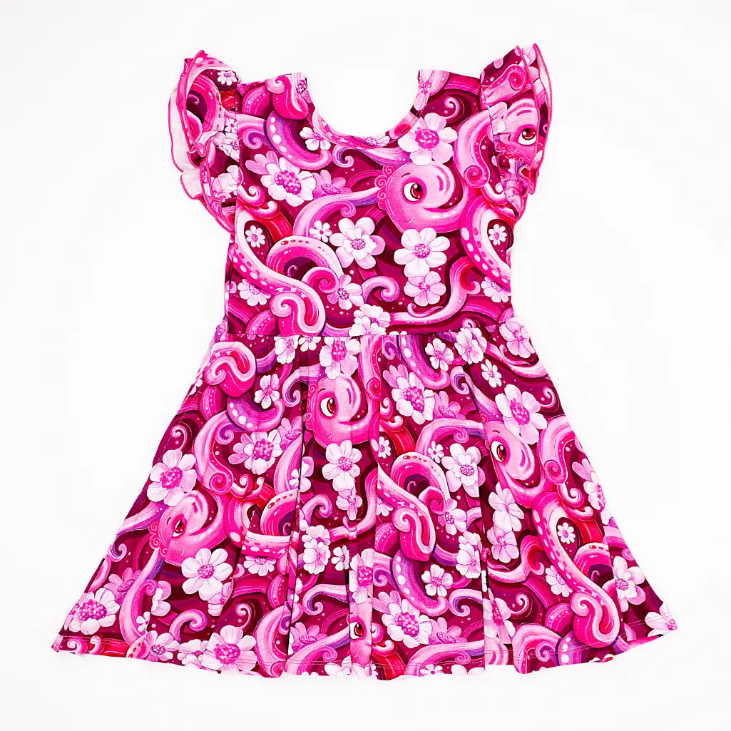 Pink dress with floral and swirl patterns on a white background