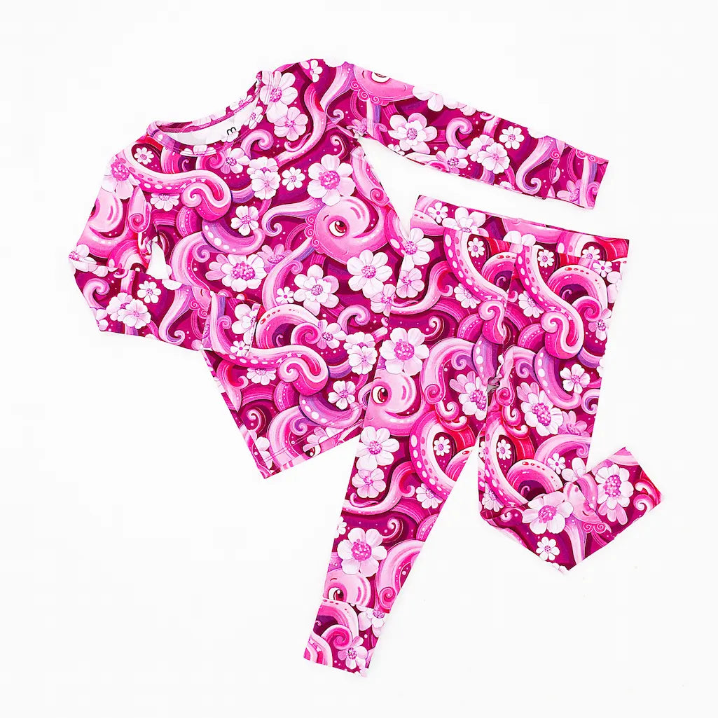 A set of children's pajamas with a playful pink octopus and white flower pattern.
