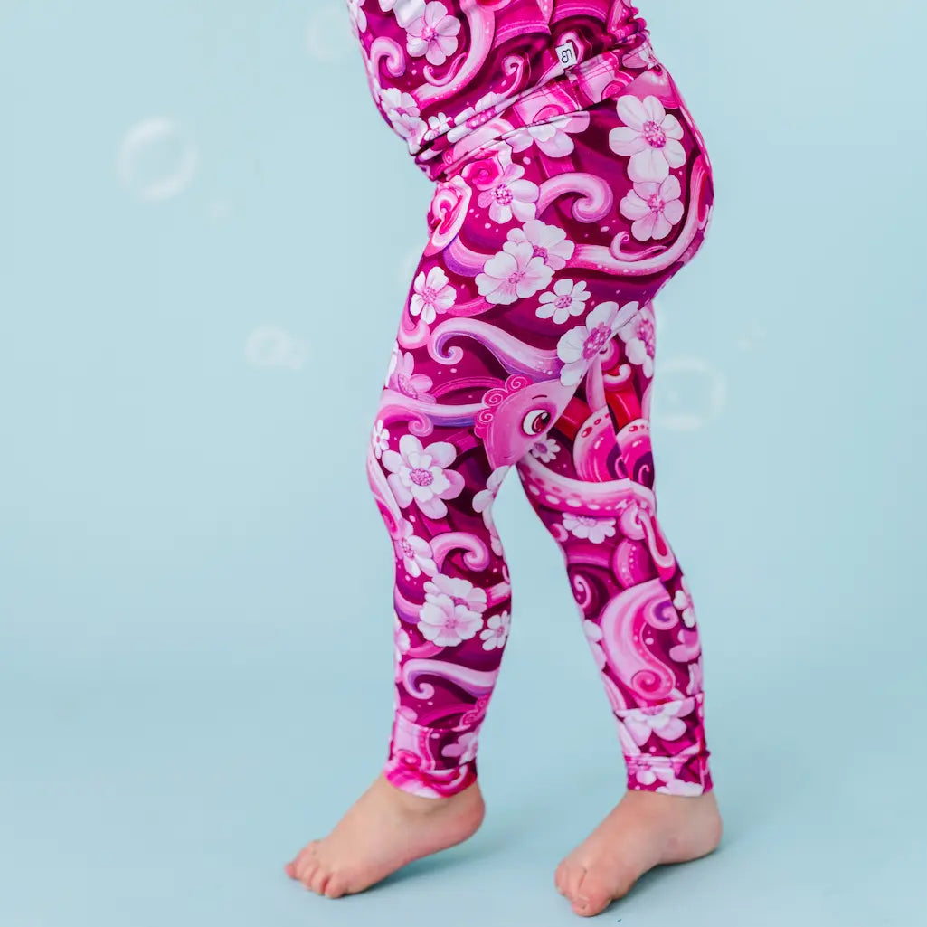 Pink leggings with floral and dragon design on a blue background
