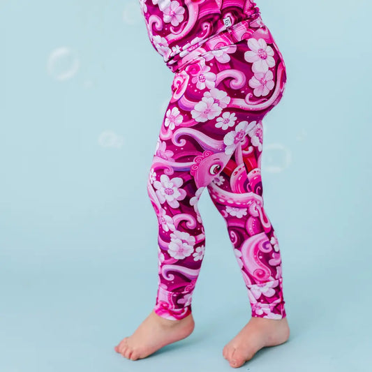 Pink leggings with floral and dragon design on a blue background