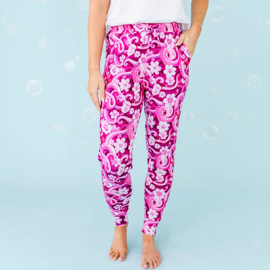 Pink and white patterned leggings worn by a person on a light blue background.