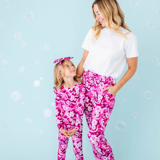 Woman and child in pink patterned pants on a light blue background