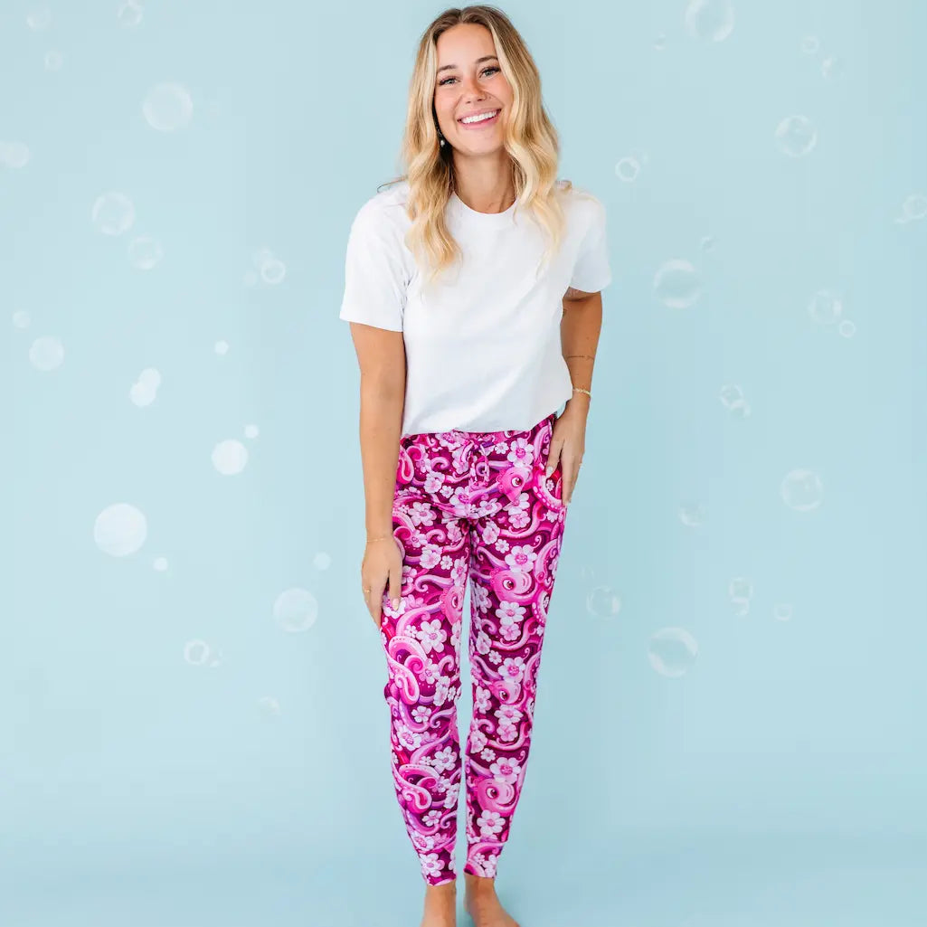 Woman wearing a white t-shirt and pink floral leggings on a light blue background.