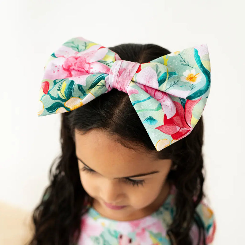 Child wearing a colorful floral headband with a white background