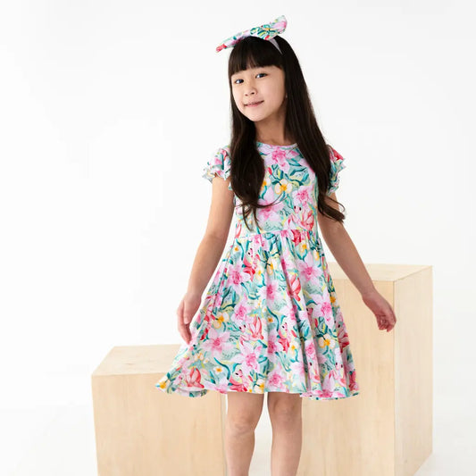 Young girl wearing a floral dress with a white background