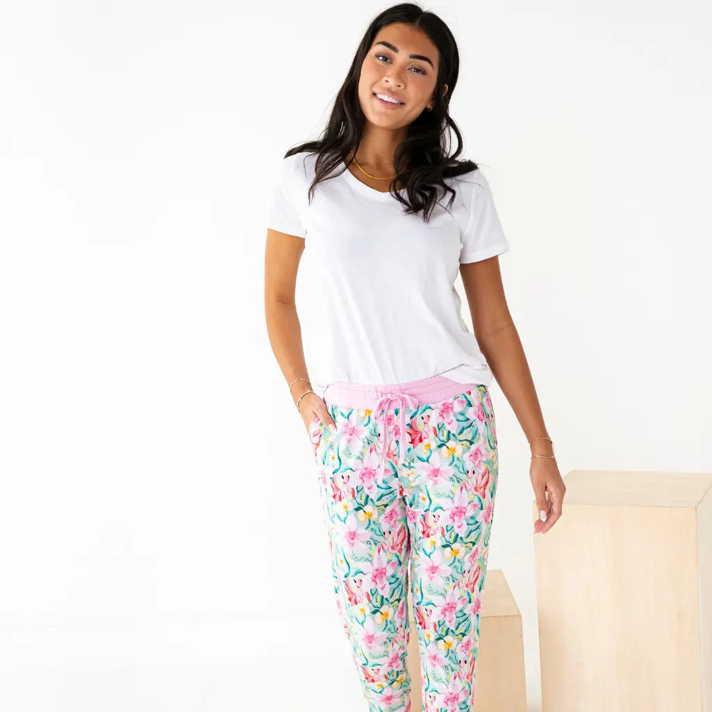 Woman wearing a white t-shirt and floral pajama pants on a white background