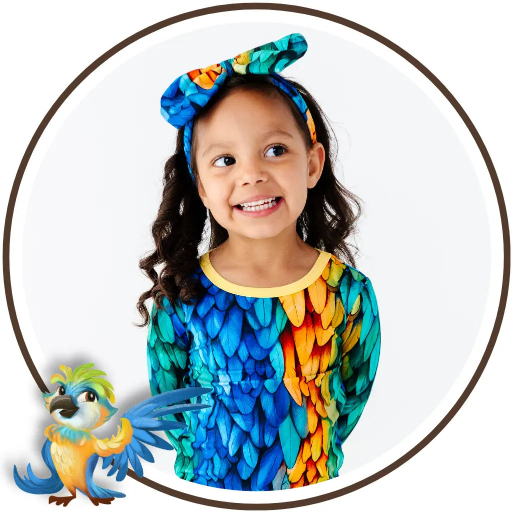 Child wearing a colorful parrot-themed outfit with a matching headband, surrounded by parrot illustrations.