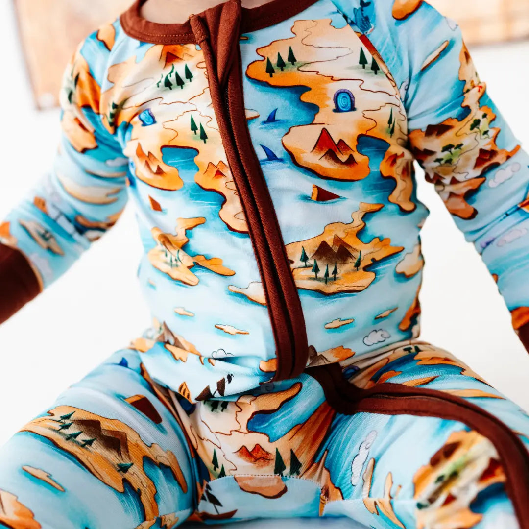 Children's onesie with a nature-themed design on a plain background