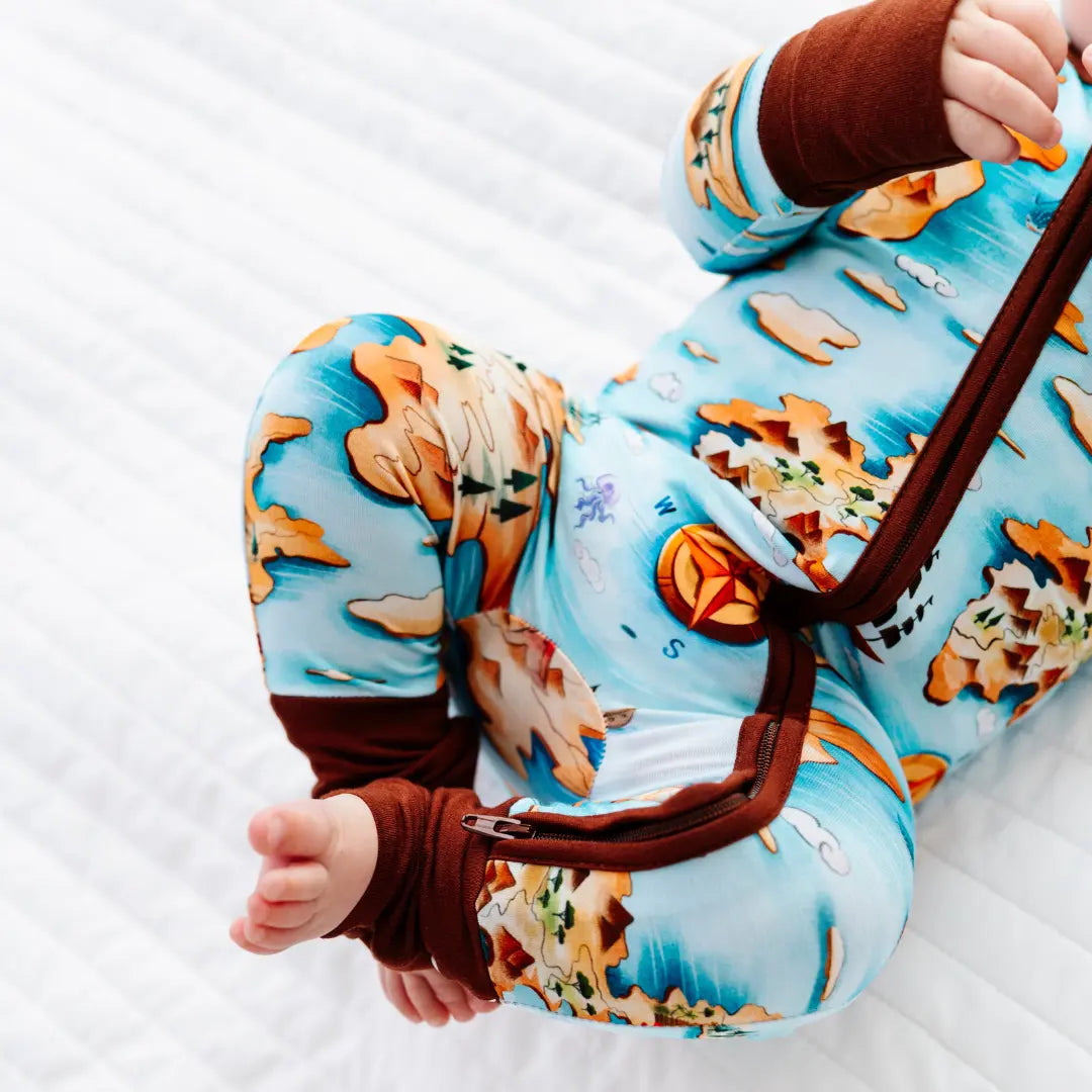 Baby in a colorful onesie with animal patterns on a white background