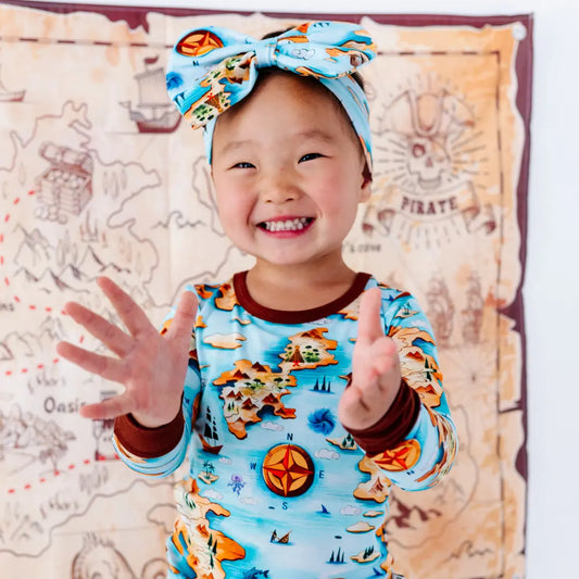 Child wearing a colorful outfit with a map background