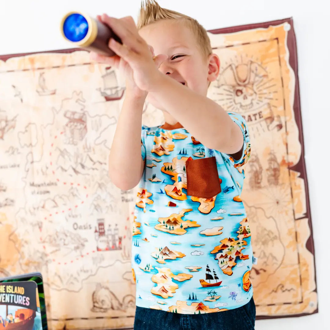 Child playing with a toy telescope in front of a map