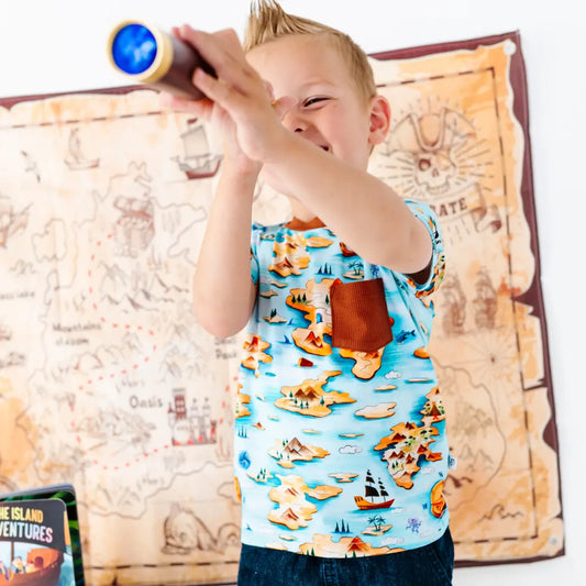 Child playing with a toy telescope in front of a map