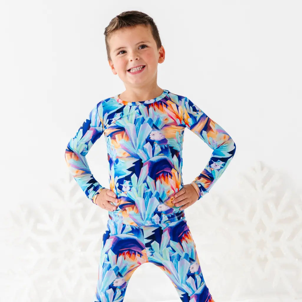 Child wearing a colorful long-sleeve shirt with a floral pattern on a white background