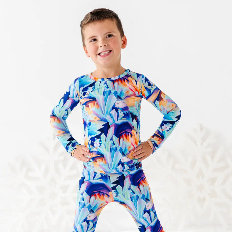 Child wearing a colorful long-sleeve shirt with a floral pattern on a white background