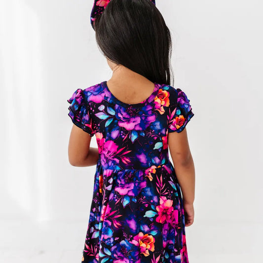 Child wearing a colorful floral dress on a white background