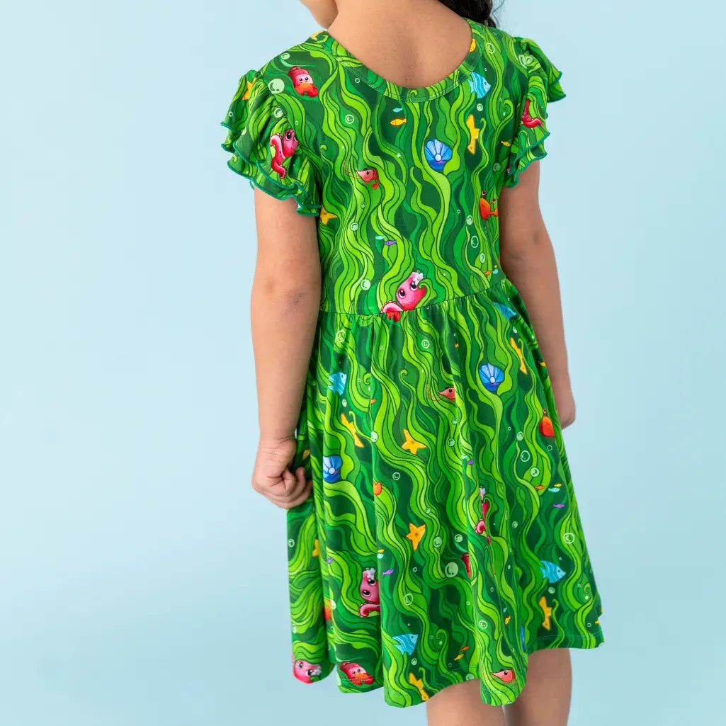 Green dress with colorful patterns on a light blue background