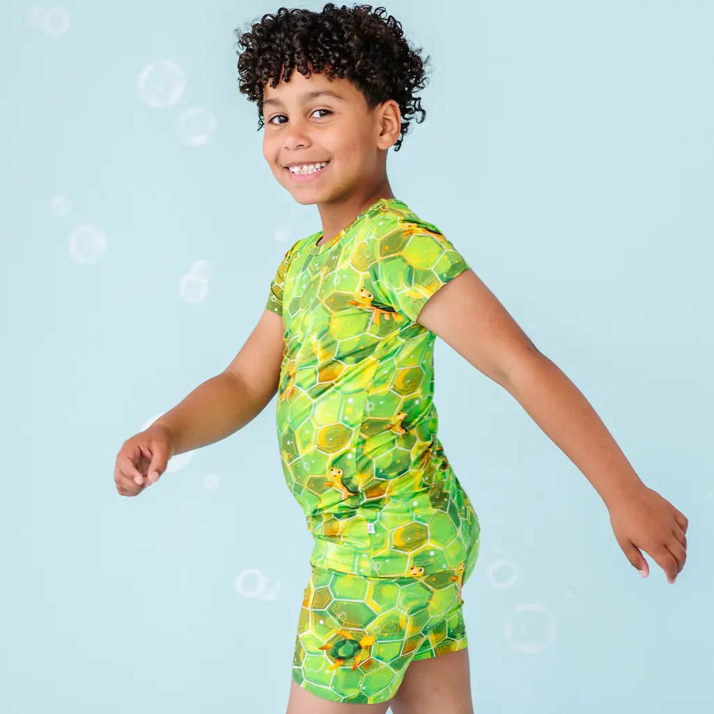 Child wearing a green patterned dress on a light blue background
